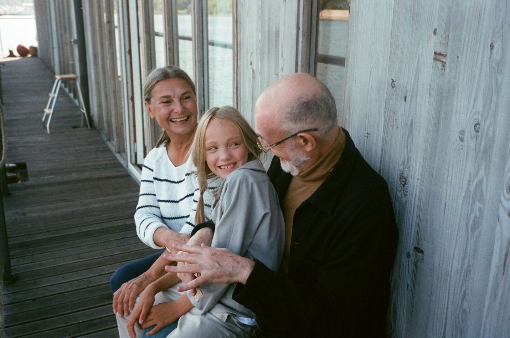 Senior couple hugging with grandchild outdoors
